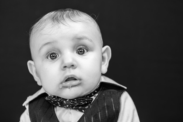 Foto retrato en primer plano de un niño lindo contra un fondo negro
