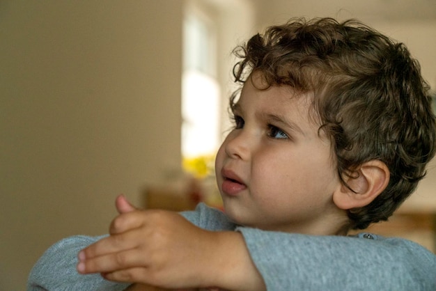 Foto retrato en primer plano de un niño lindo mirando lejos en casa