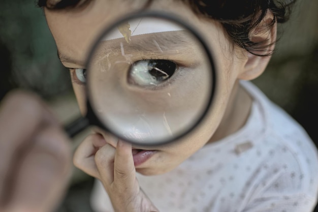 Retrato en primer plano de un niño visto a través de una lupa