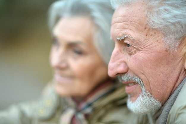 Retrato de primer plano de una pareja senior sonriente en ropa de abrigo al aire libre