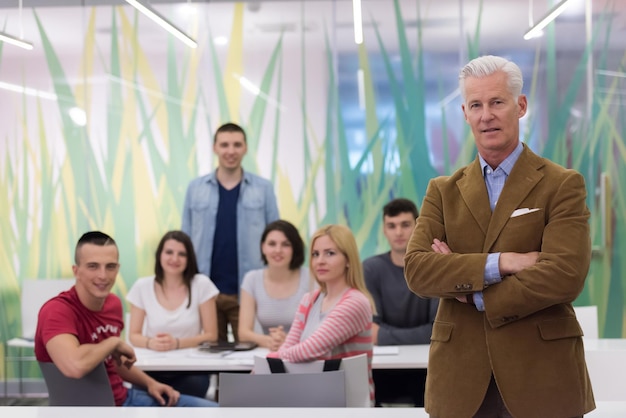 retrato de profesor confiado, grupo de estudiantes en segundo plano