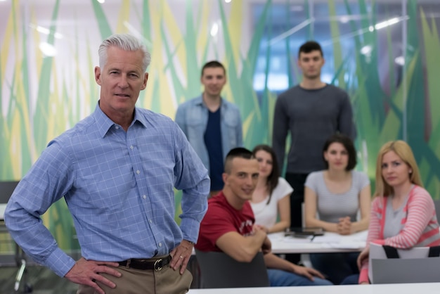 Foto retrato de profesor confiado, grupo de estudiantes en segundo plano