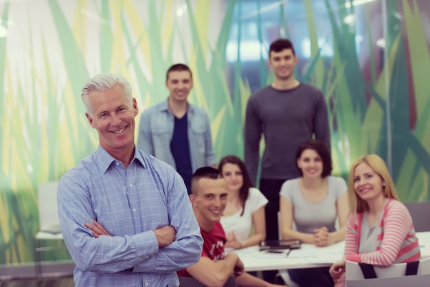 Foto retrato de profesor confiado, grupo de estudiantes en segundo plano
