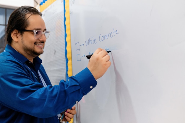 Retrato de profesor de inglés sonriente retorciéndose con el creador en la pizarra