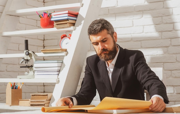 Retrato de profesor masculino trabajando en el escritorio en clase Tutor profesor mentor hombre en el escritorio Estudiando el concepto de formación de aprendizaje