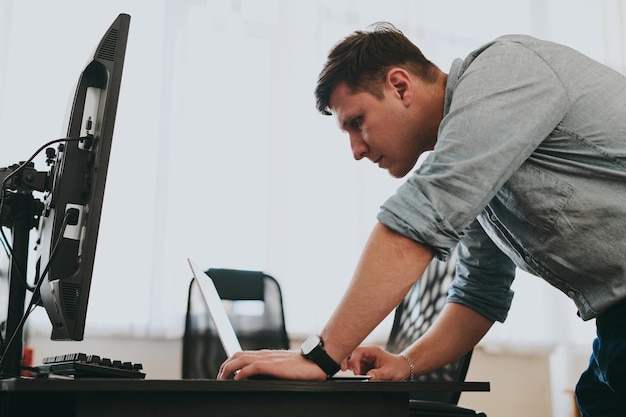 Foto retrato de un programador profesional que trabaja concentrado en computadoras en diversas oficinas. desarrollo de tecnologías de ti modernas de aplicaciones de programas de inteligencia artificial y concepto de videojuegos.