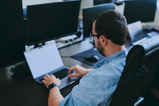 Retrato de un programador profesional que trabaja concentrado en computadoras en diversas oficinas Tecnologías informáticas modernas Desarrollo de programas de inteligencia artificial Aplicaciones y concepto de videojuegos