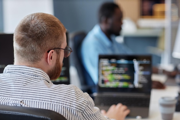 Retrato de un programador trabajando en código en una oficina moderna