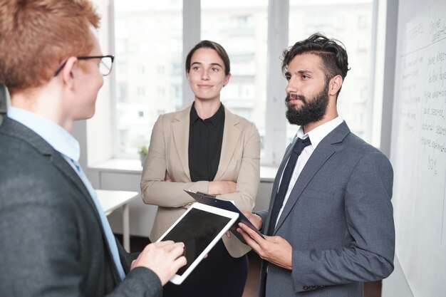 Retrato del proyecto de inicio de planificación del equipo de negocios creativos de pie junto a la pizarra en la oficina