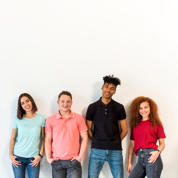 Foto retrato de un pueblo multirracial de pie contra la pared blanca