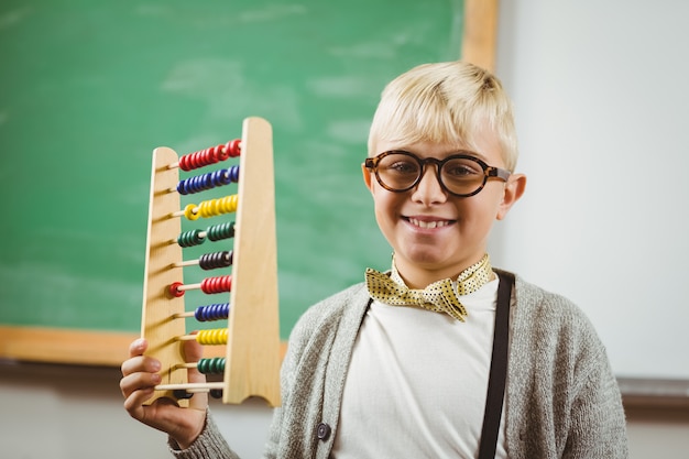 Retrato de la pupila sonriente vestida como profesor sosteniendo el ábaco en un aula