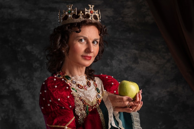 Foto retrato de reina con corona y manzana