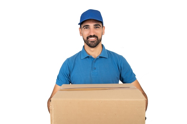 Retrato de un repartidor con cajas de cartón contra la pared blanca. Concepto de entrega y envío.