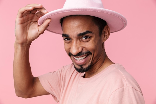 Retrato rindo de homem afro-americano com chapéu isolado em rosa