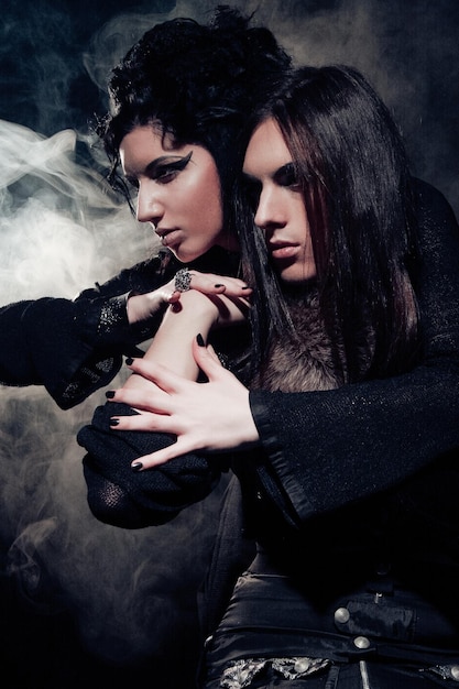 Retrato romántico de una joven pareja gótica hombre y mujer sobre fondo oscuro