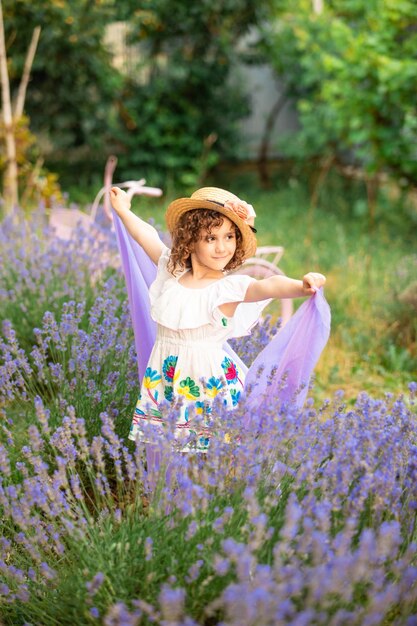 Retrato romántico o chica encantadora con sombrero de paja en lavanda