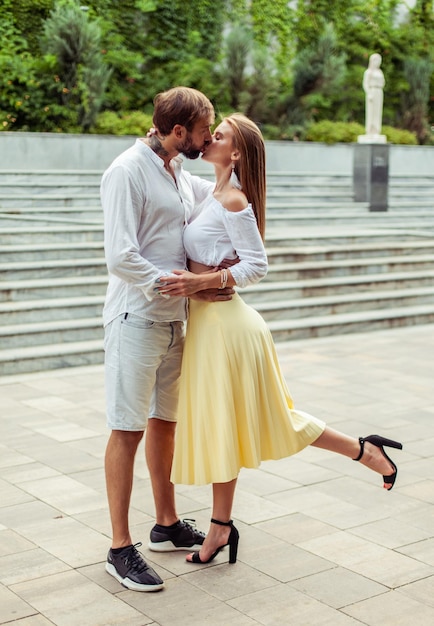 Foto retrato romántico de una pareja enamorada besándose en un parque de la ciudad