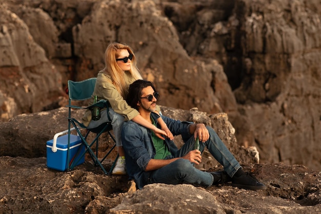 retrato, de, romántico, pareja joven, teniendo, al aire libre, comida campestre, en, rocas, y, se abrazar