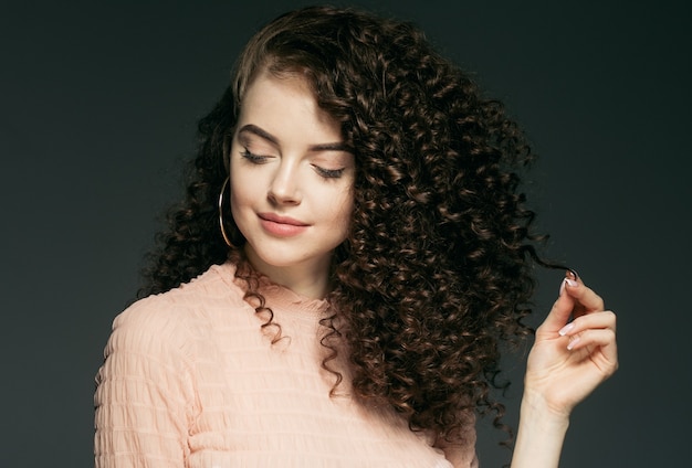 Retrato de rostro hermoso de mujer de pelo rizado