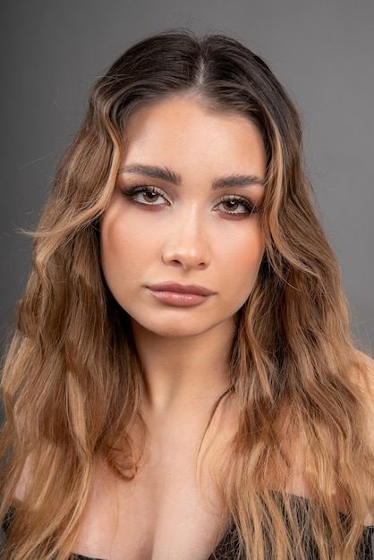 Retrato de rostro de joven hermosa modelo con cabello largo y bien cuidado y piel de maquillaje profesional