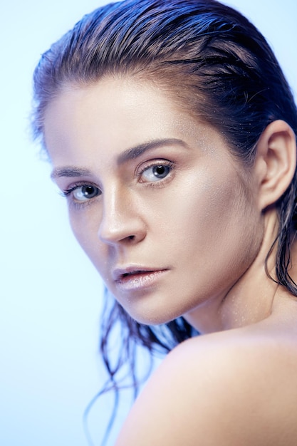 Retrato de rostro de mujer hermosa de cerca sobre fondo azul