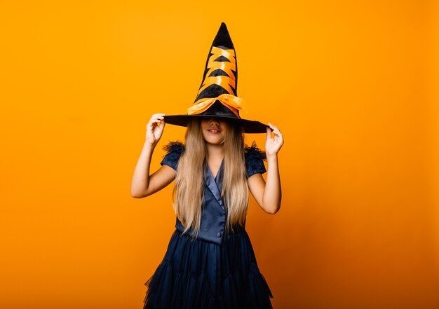 Retrato de una rubia alegre en un traje de bruja posando para la cámara. Víspera de Todos los Santos.