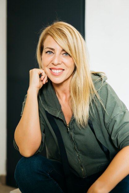 Retrato de una rubia, cabello largo y liso, hermosa sonrisa, mujer de mediana edad