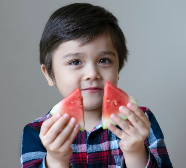 Retrato saludable niño comiendo sandía fresca