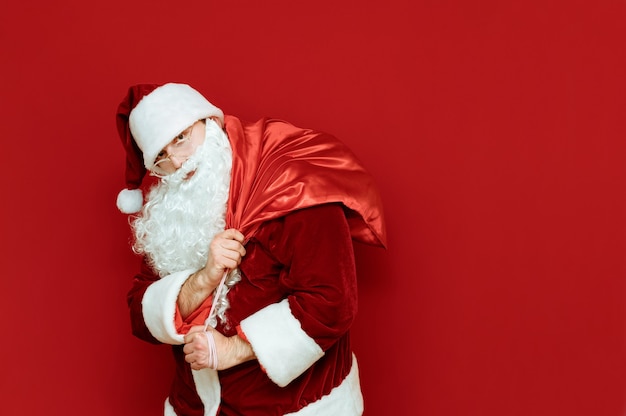 Retrato de Santa Claus con bolsa pesada con regalos