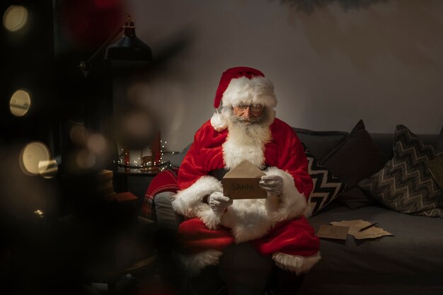 Foto retrato de santa claus leyendo carta de navidad