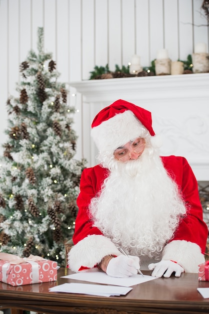 Retrato de Santa Claus respondiendo cartas de Navidad