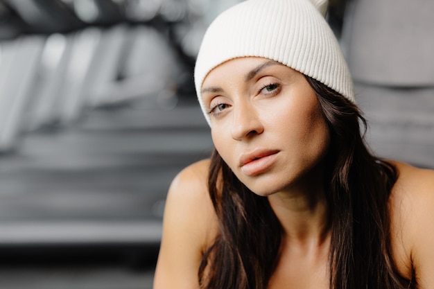 Retrato seguro hermosa joven morena lleva gorro blanco