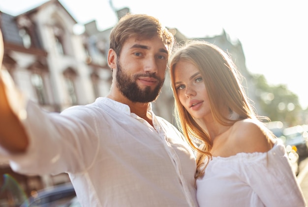 Retrato selfie de una joven y hermosa pareja en la ciudad