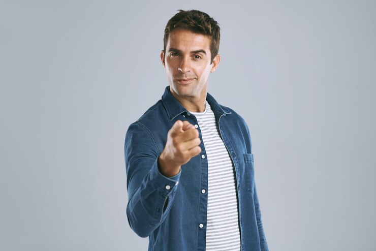 Foto retrato de señalización y hombre en el estudio confiado y elección de usted reclutamiento y empleado en maqueta fondo azul cara y gesto de persona contratación y mano para opinión moda y espacio