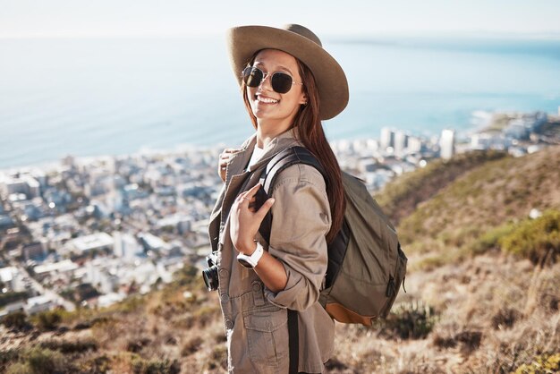 Foto retrato de senderismo y mujer con vista fitness y felicidad para hacer ejercicio, aire fresco y equilibrio cara feliz mujer excursionista y dama con gafas de sol naturaleza y libertad en mochila de montaña o explorar