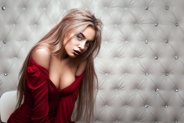 Retrato sexy de uma loira de vestido vermelho