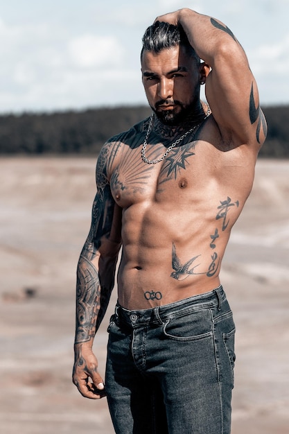 Retrato sexy do modelo masculino em topless bonito musculoso na praia