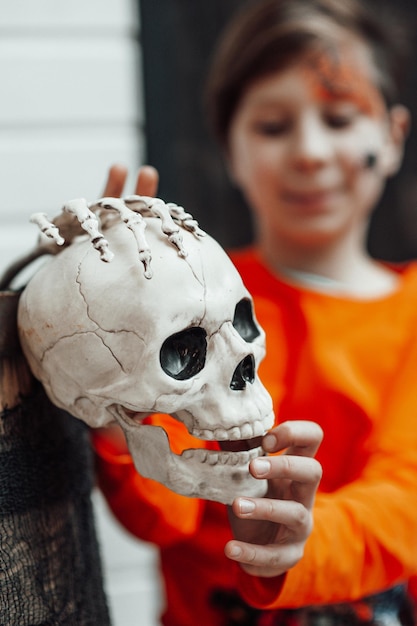 Retrato de sincero adolescente auténtico con la cara pintada en la fiesta de esqueletos decorados Halloween