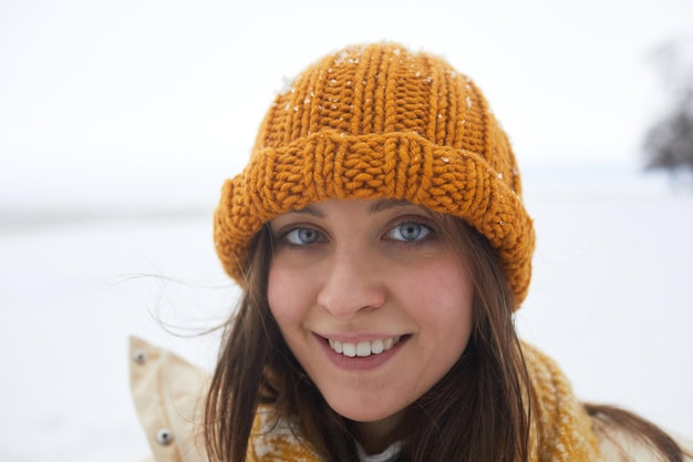 Retrato sincero de jovem no inverno sorrindo para a câmera com olhos azuis brilhantes copiam o espaço