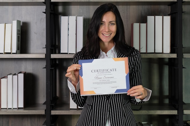 Retrato sincero de uma jovem e bela empresária caucasiana recebendo um certificado de apreço