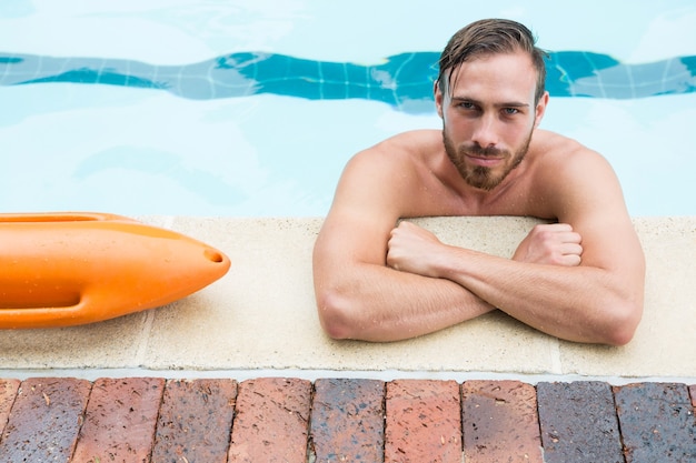 Retrato de socorrista apoyado en la piscina