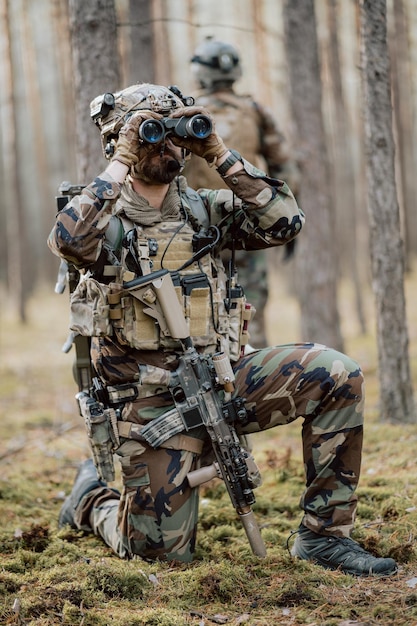 Retrato de un soldado barbudo de mediana edad con un uniforme militar del bosque y un casco con auriculares