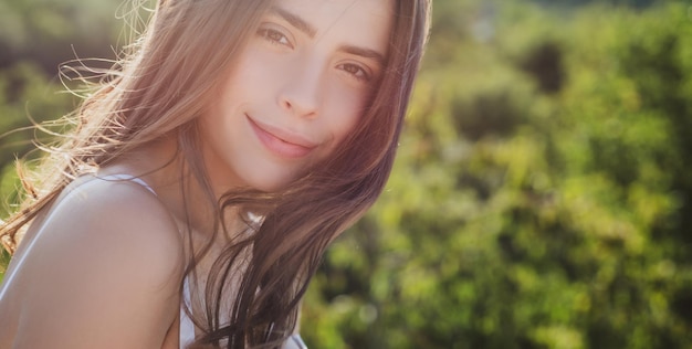 Retrato soleado de belleza natural de niña sonriente en el parque