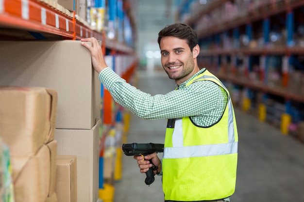 Retrato de sonriente caja de escaneo de trabajador de almacén