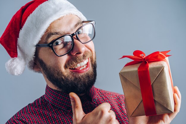 Foto retrato de sonriente chico barbudo con sombrero de santa