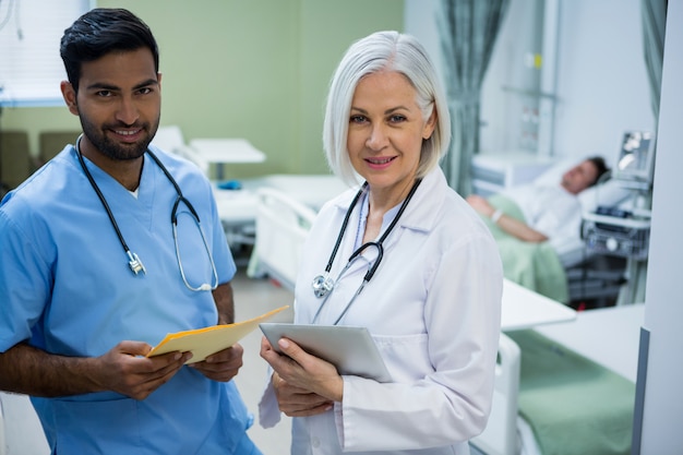 Retrato de sonriente cirujano y médico en sala