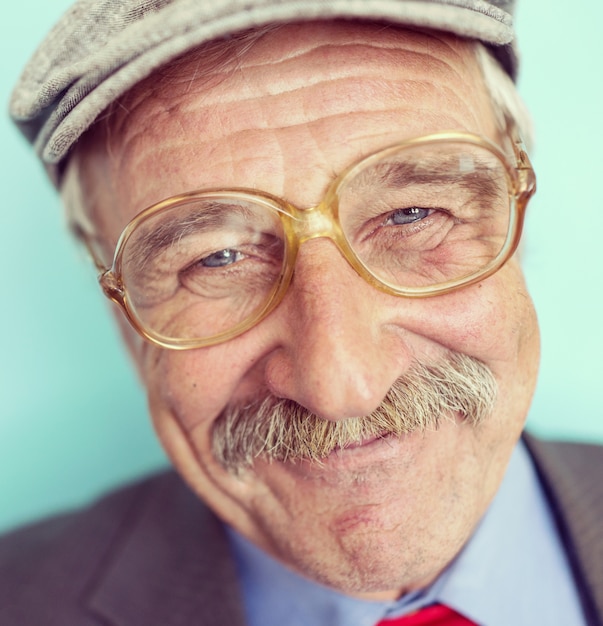 Retrato de un sonriente y confiado hombre maduro con bigote, arrugas y cabello gris sonriendo