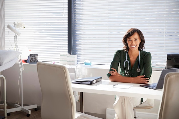 retrato, de, sonriente, doctora, con, estetoscopio, sentado, atrás, escritorio, en, oficina