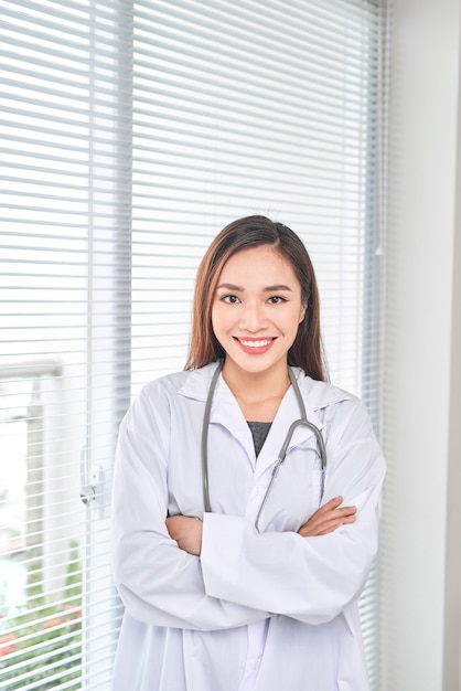 Retrato de sonriente doctora de pie posando en la oficina de su hospital., Concepto de ocupación médica y sanitaria.