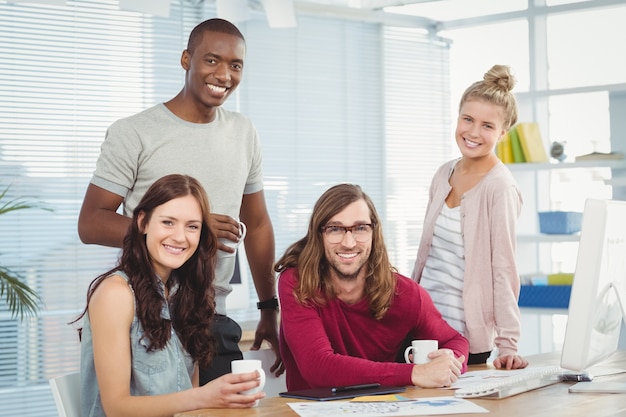 Retrato de sonriente equipo de negocios en el escritorio de la computadora